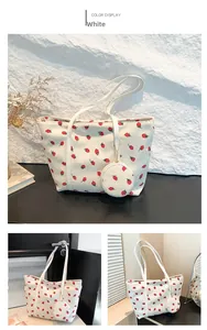 Detail of white corduroy tote bag with strawberry print and round mini coin purse