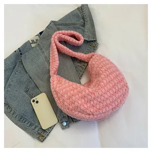 Detail of pink plush hobo bag with pleated texture, crescent shape and wide shoulder strap