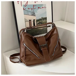 Detail of vintage brown tote bag with metallic zippers and decorative buckle straps