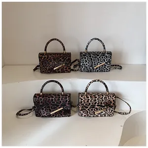 Detailed display of leopard print crossbody bags in four colors on minimalist stands