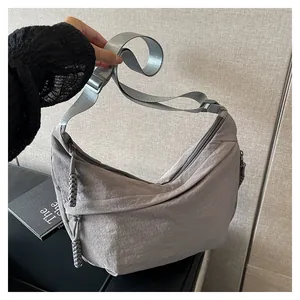 Détail du sac croissant en nylon gris avec tissu texturé et tirette de zip tressée