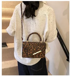 Detail of trendy leopard print handbag with metallic accent and crossbody strap
