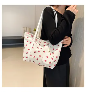 Detailed shot of white corduroy tote bag with strawberry print and mini pouch