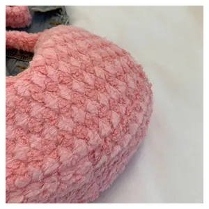 Detail of pink plush shoulder bag with rhombic texture and soft faux fur material