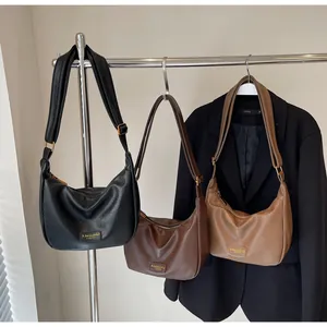 Gros plan sur trois sacs hobo en cuir texturé de couleurs noir, marron foncé et marron clair