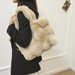 Schicke cremefarbene Plüschtasche aus Kunstpelz für Damen getragen zum schwarzen Blazer
