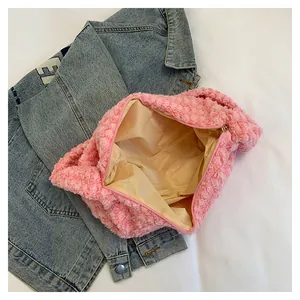 Detail view of pink plush puffer bag with zipper closure and beige fabric lining