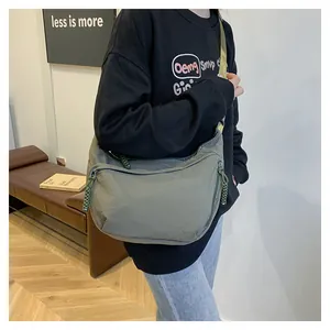 Détail du grand sac bandoulière en nylon kaki en forme de croissant avec sangle réglable