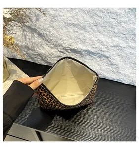 Detailed top view of leopard print makeup bag showing beige lining and black zipper closure