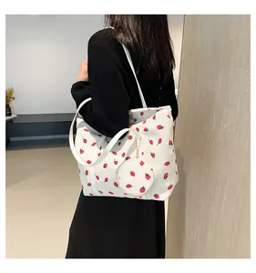 Detail view of white corduroy strawberry tote bag with round matching coin purse