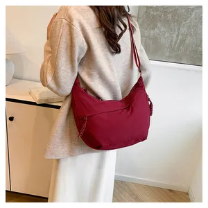 Détail du sac hobo en nylon bordeaux avec tirette tressée et bandoulière réglable