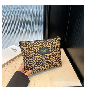 Close-up of leopard print makeup bag with a stylish black leather fashion label