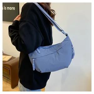 Mannequin portant un sac bandoulière en nylon bleu clair avec sangle large réglable