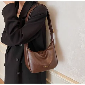 Détail du sac hobo en cuir PU marron foncé texturé avec plaque métallique dorée chic