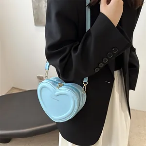 Minimalist sky blue heart-shaped crossbody bag with embossed logo and gold hardware