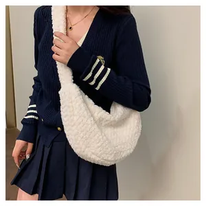 Close-up of white plush lamb wool puffy shoulder bag with soft texture and wide strap