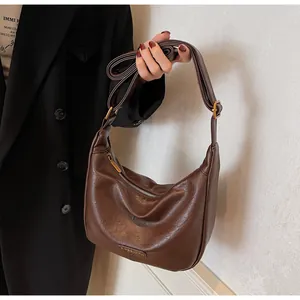 Détail du sac hobo marron foncé en simili cuir avec texture rétro et fermeture éclair argentée