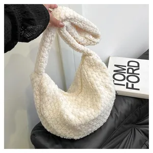 Close-up of creamy white sherpa hobo bag with soft fleece texture and thick shoulder strap