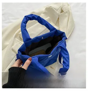 Detailansicht des geräumigen Innenlebens einer blauen gesteppten Nylon-Beuteltasche mit Magnet