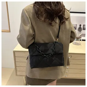 Détail du grand sac bandoulière noir matelassé avec chaîne et texture en nylon imperméable