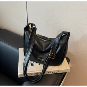Détail du sac hobo noir texturé avec fermeture éclair dorée vintage et plaque logo