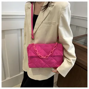 Détail du sac bandoulière rose fuchsia avec matelassage en losange et chaîne en plastique