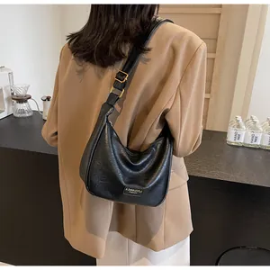 Détail du sac hobo en similicuir noir avec bandoulière réglable et boucle dorée