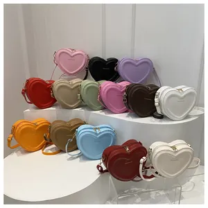 Collection of heart-shaped crossbody bags in multiple colors displayed on white steps