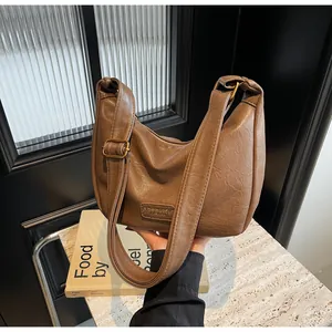 Détail du sac hobo en cuir marron vintage avec texture et bandoulière réglable