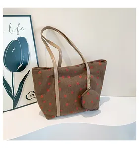 Detail of strawberry print corduroy tote bag with matching round coin purse accessory