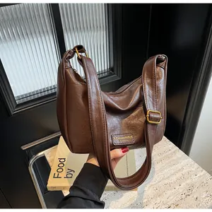 Détail du sac à bandoulière vintage en similicuir marron foncé avec boucle en métal rétro