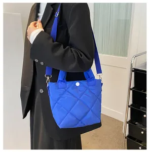 Detailansicht der gesteppten kleinblauen Umhängetasche mit Rautenmuster am Model