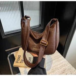 Gros plan du sac marron à texture froncée et boucle réglable en laiton au style vintage
