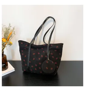 Detail of strawberry print corduroy tote bag with round coin purse and faux leather straps