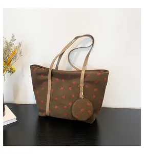 Detail of brown corduroy tote bag with red heart pattern and matching mini coin purse