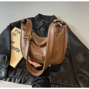 Détail du sac hobo en similicuir marron avec texture vintage et bandoulière réglable