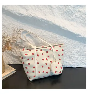 Close-up of cream corduroy tote bag with strawberry prints and matching coin pouch