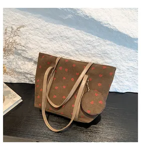 Detail of brown corduroy tote bag with strawberry print and round matching mini pouch