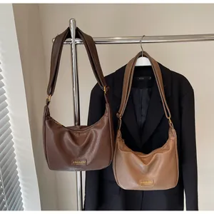 Détail de sacs demi-lune rétro en simili cuir marron et café avec texture grainée