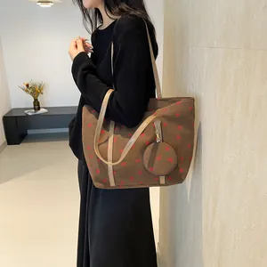 Brown corduroy tote bag with strawberry print and mini pouch shown on shoulder