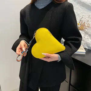 Chic yellow heart-shaped leather purse with a colorful LOVE woven strap for daily styling