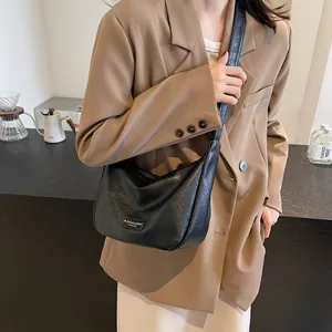 Sac hobo noir chic avec texture en cuir froissé et plaque métallique élégante