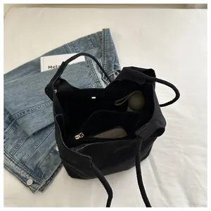 Top view of black canvas bucket bag with inner zipper pouch and spacious interior