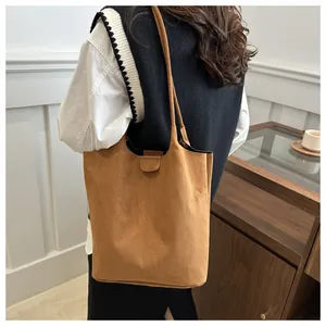 Texture dettagliata della borsa tote in pelle scamosciata marrone con chiusura magnetica