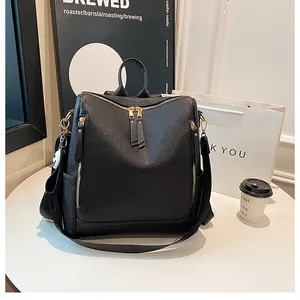 Detailaufnahme des schwarzen Lederrucksacks mit goldenen Reißverschlüssen und Seitentasche