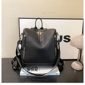 Detail eines schwarzen PU-Rucksacks mit Litschimuster, Goldzipper und Gänseblümchen