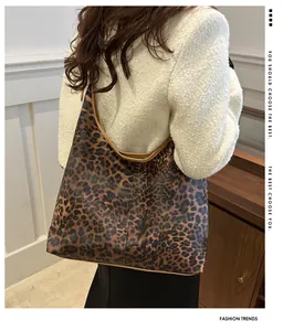 Grand sac fourre-tout léopard avec bordure marron porté à l'épaule par un mannequin
