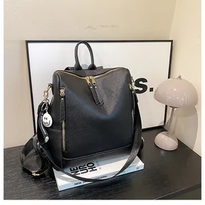 Nahaufnahme des schwarzen Lederrucksacks mit goldenen Details und Smile-Anhänger