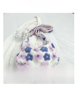 Detail of white plush tote bag featuring blue and purple floral 3D embroidery and soft texture