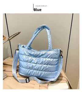 Detail van de blauwe gewatteerde tas met metallic textuur en verstelbare schouderriem